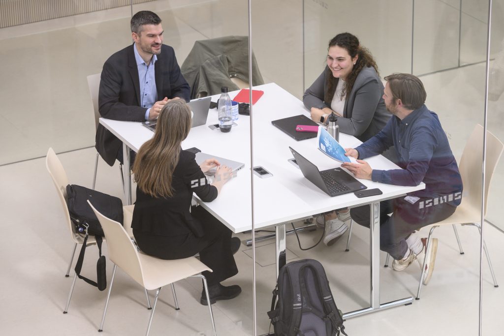 Personen sitzen für ein Meeting in einem Arbeitsraum